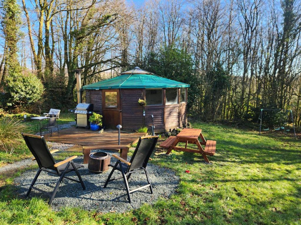 a gazebo with two chairs and a table and a picnic table at Galtee Glamping in wooden yurt in Mitchelstown