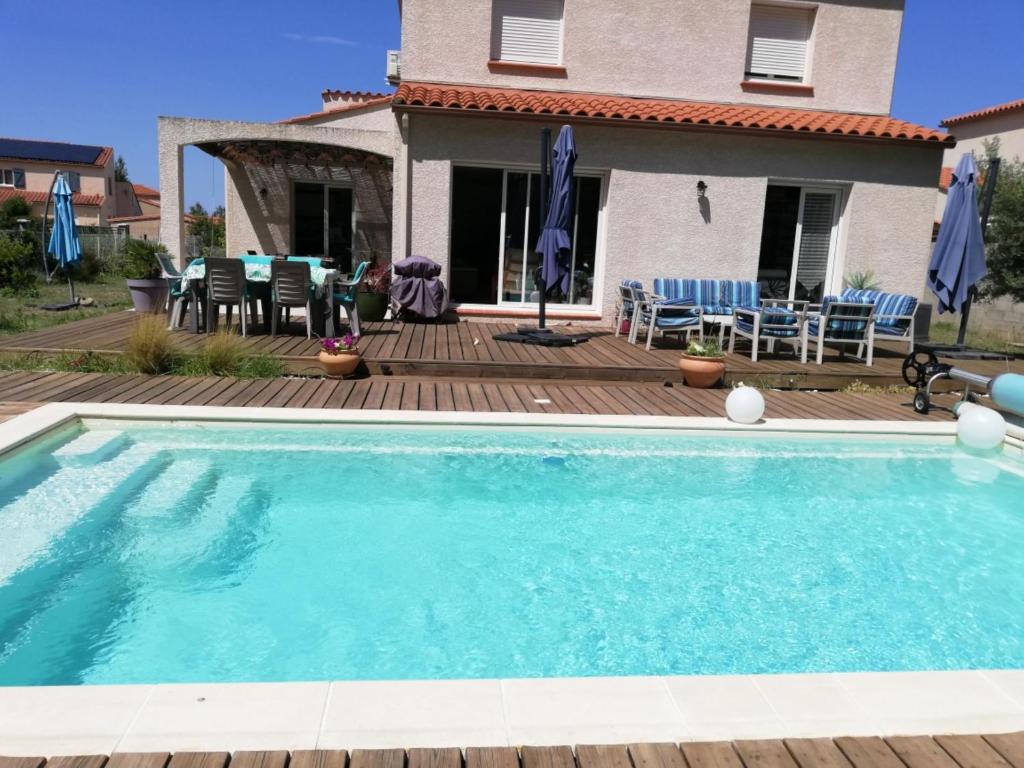 a swimming pool in front of a house at La Salamandre 66 in Saint-Génis