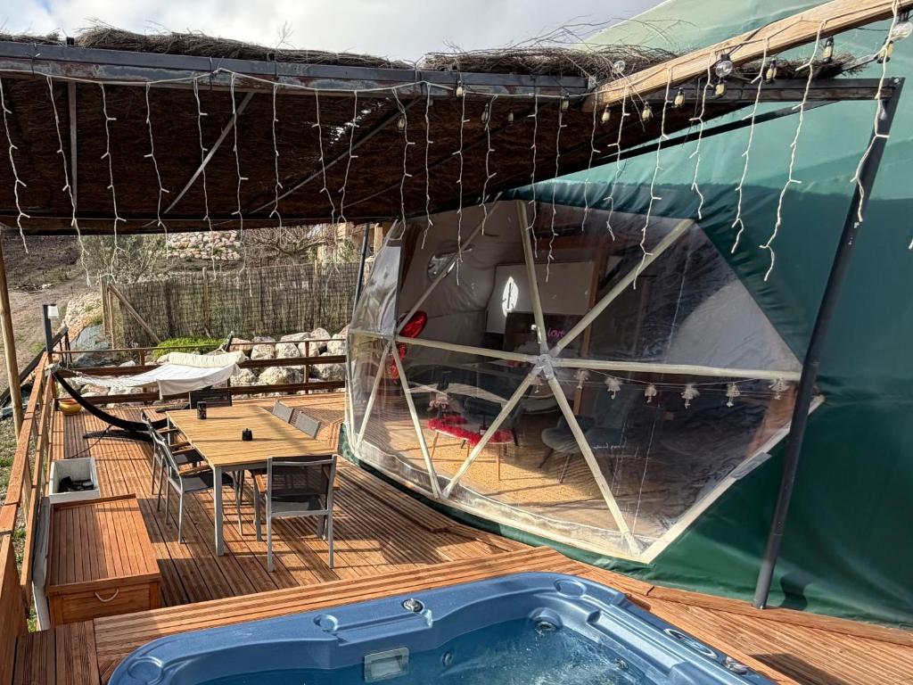 a deck of a boat with a table and a pool at Bulle Insolite avec Spa Privatif in Durban-Corbières