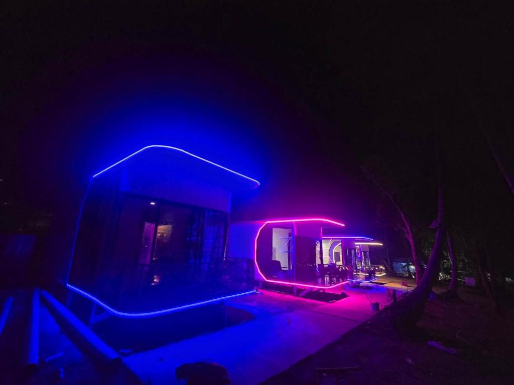 a house lit up in blue and red at night at Avatar Resort Phangan Thailand in Ban Nua