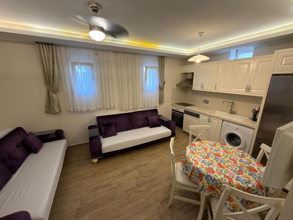 a kitchen and living room with a couch and a table at Çeşme Kale Taş Apart in Çeşme