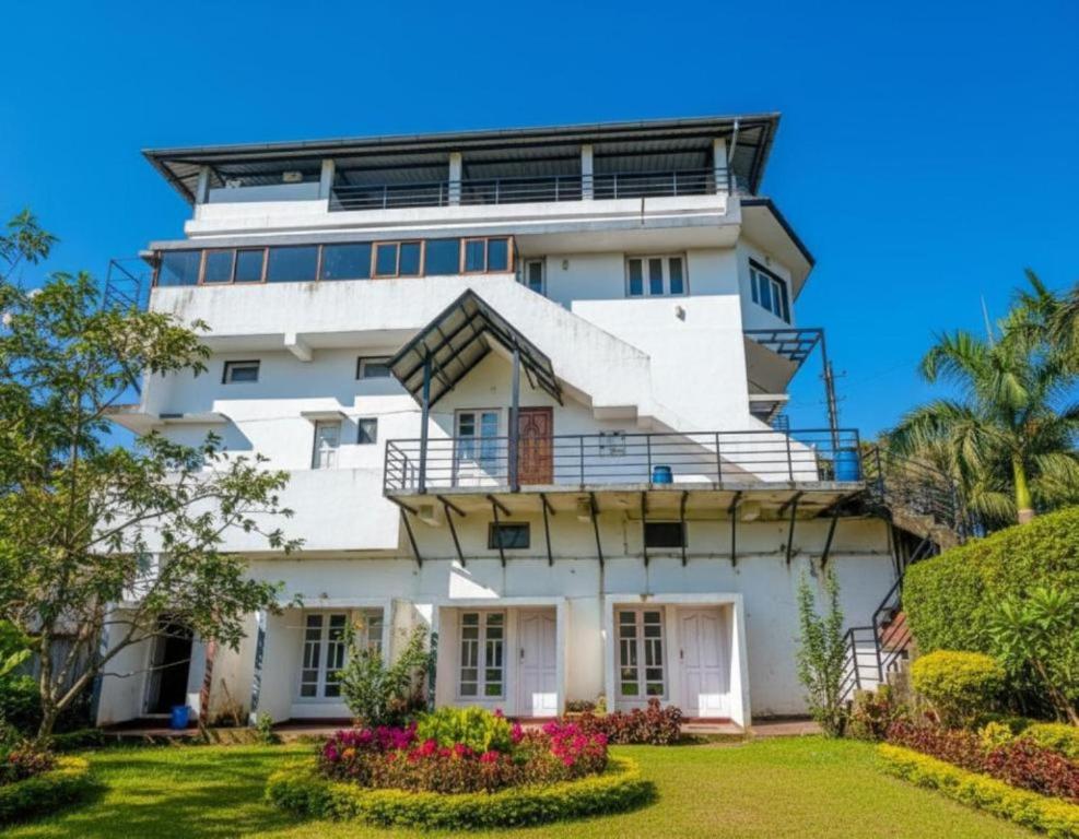 an image of a white building with a garden at Coorg mansion in Madikeri
