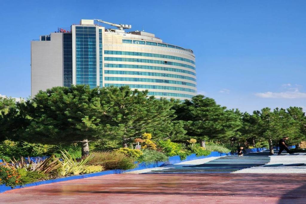 a walkway in a park with a tall building at BİG THERMAL Spa Resort in Kalankaldı