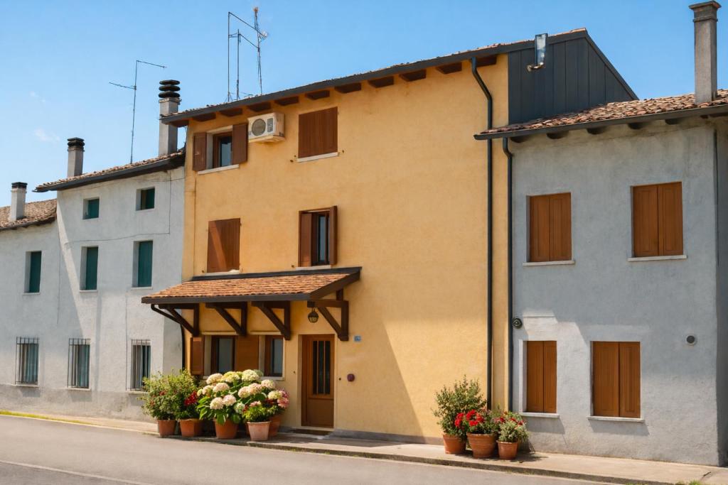 a building with potted plants in front of it at Affittacamere Al Fiume in Flambruzzo