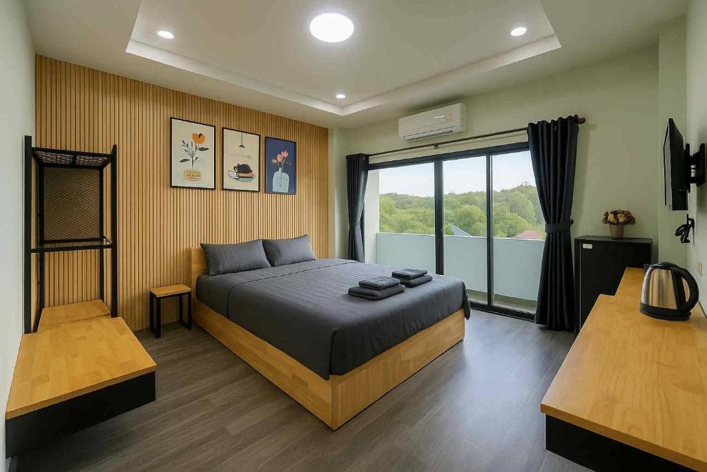 a bedroom with a bed and a large window at SiLin Hotel in Ban Nong Pling