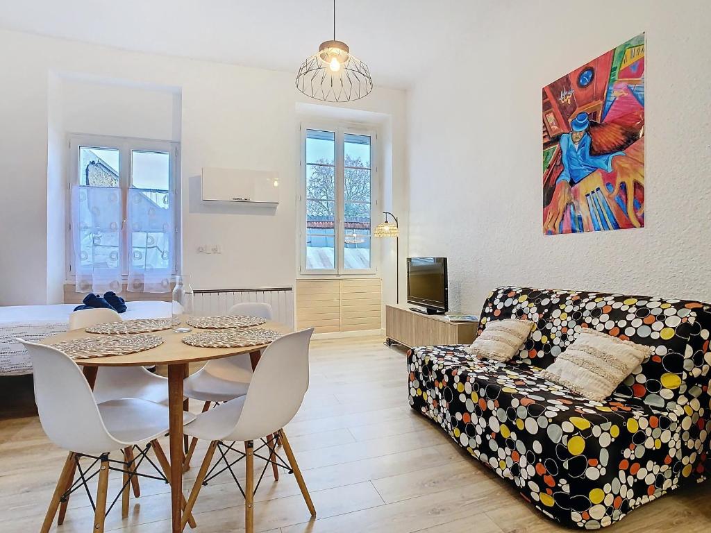 a living room with a table and a couch at Le Pianiste in Voiron