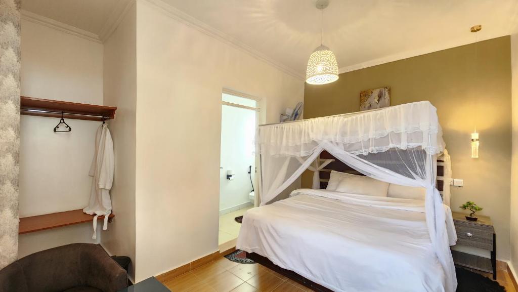a bedroom with a white bed with a canopy at Kamakis Motel & Lounge in Ruiru