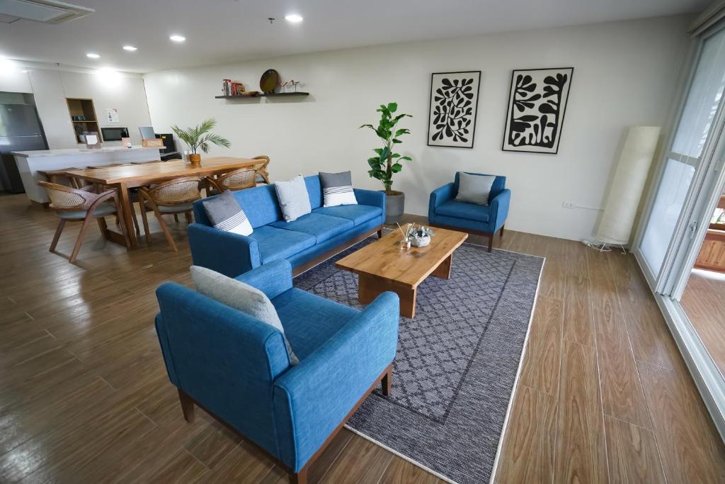 a living room with blue chairs and a table at Vine and Canopy in Olongapo