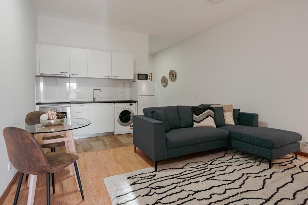 a living room with a couch and a table at Modern studio near Metro in Senhora da Hora