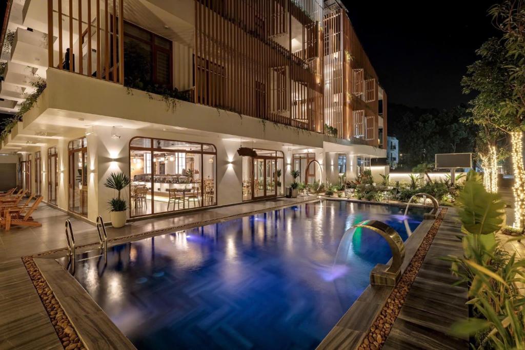 a swimming pool in front of a building at night at amaya valley tam coc hotel in Vũ Lâm