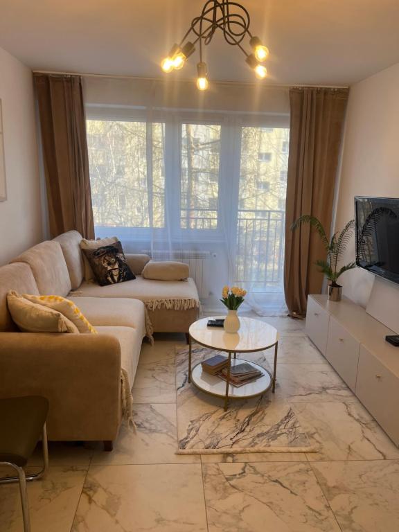 a living room with a couch and a table at Sara Apartament in Turek