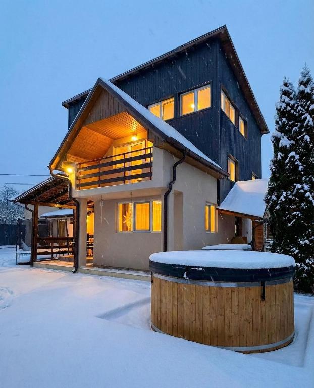 a house in the snow with a tub in front of it at Villa J'adore in Crasna