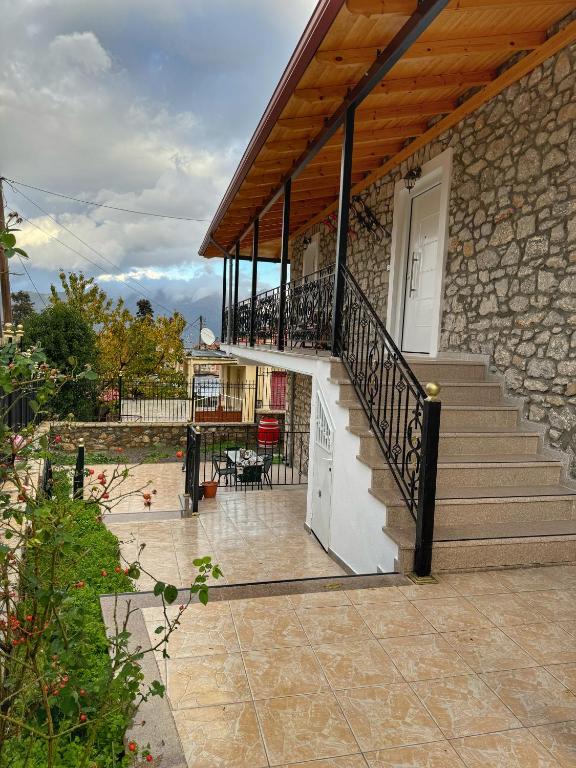 a stone house with a staircase and a patio at Petrino in Levidi
