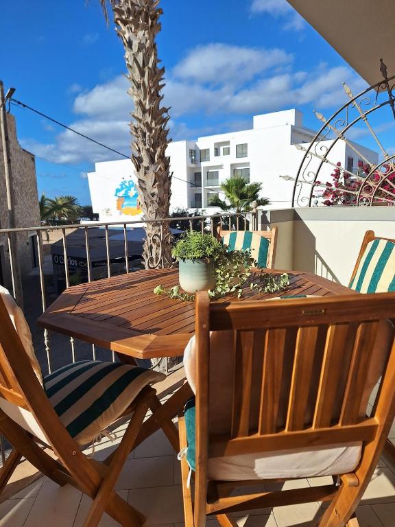 a wooden table and chairs on a balcony with a palm tree at T2 Apart - Beach View - Santa Maria Center in Santa Maria