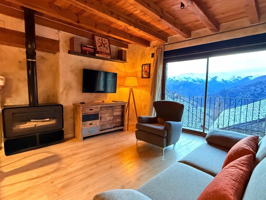 a living room with a couch and a television and a balcony at Casa Sinera - L'Amfitriona in Roní