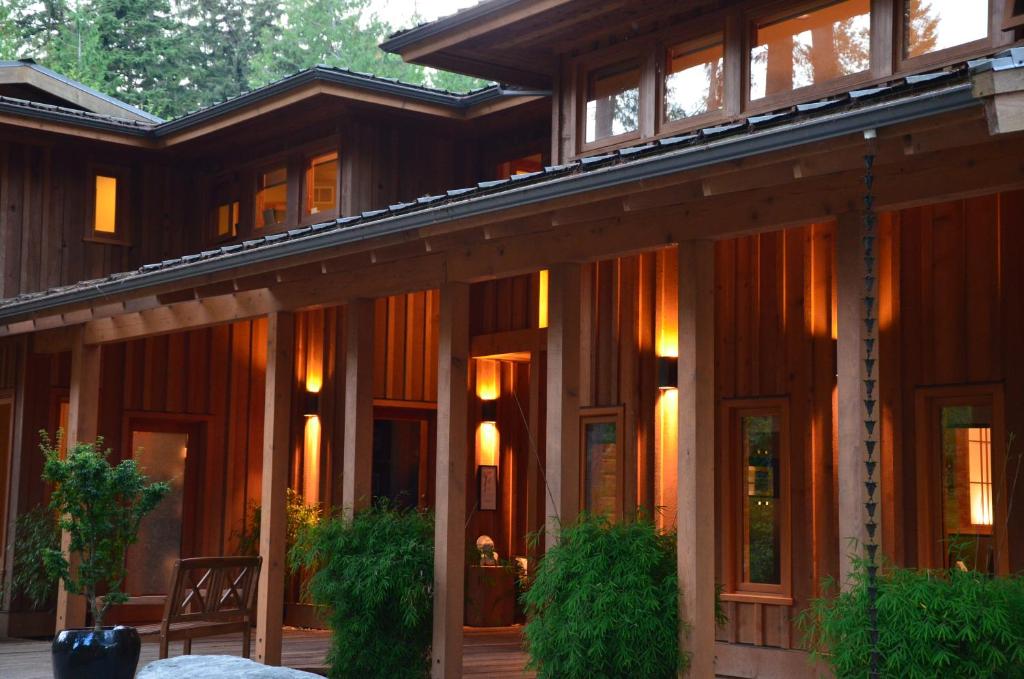 a wooden house with glass doors and windows at Shades of Jade Inn & Spa in Roberts Creek