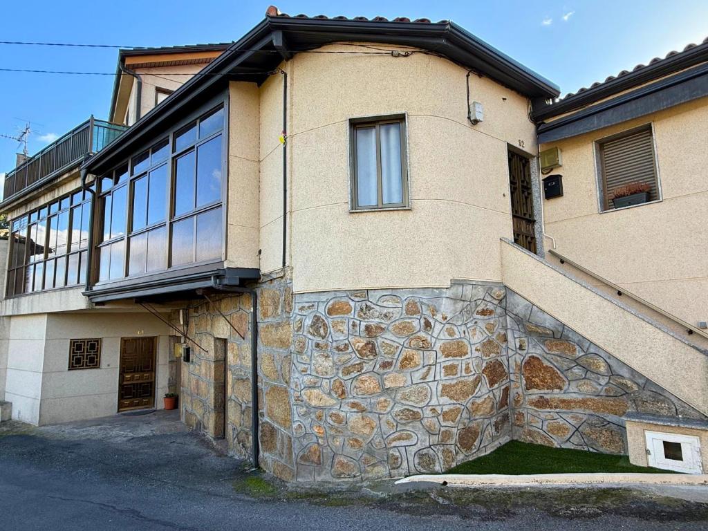 a building with a stone wall and a window at YourHouse Casa Antonio in Sobrado del Obispo