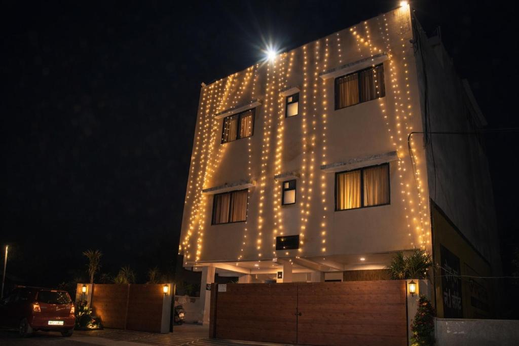 a building with lights on the side of it at night at Manas homes in Gwalior