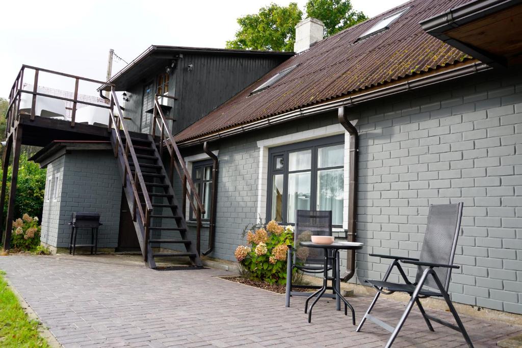 a patio with chairs and a staircase next to a building at Engure BeachHouse in Engure