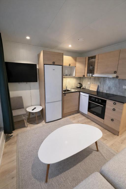 a kitchen with a white table and a white refrigerator at Arctic Sea Apartments in Hammerfest