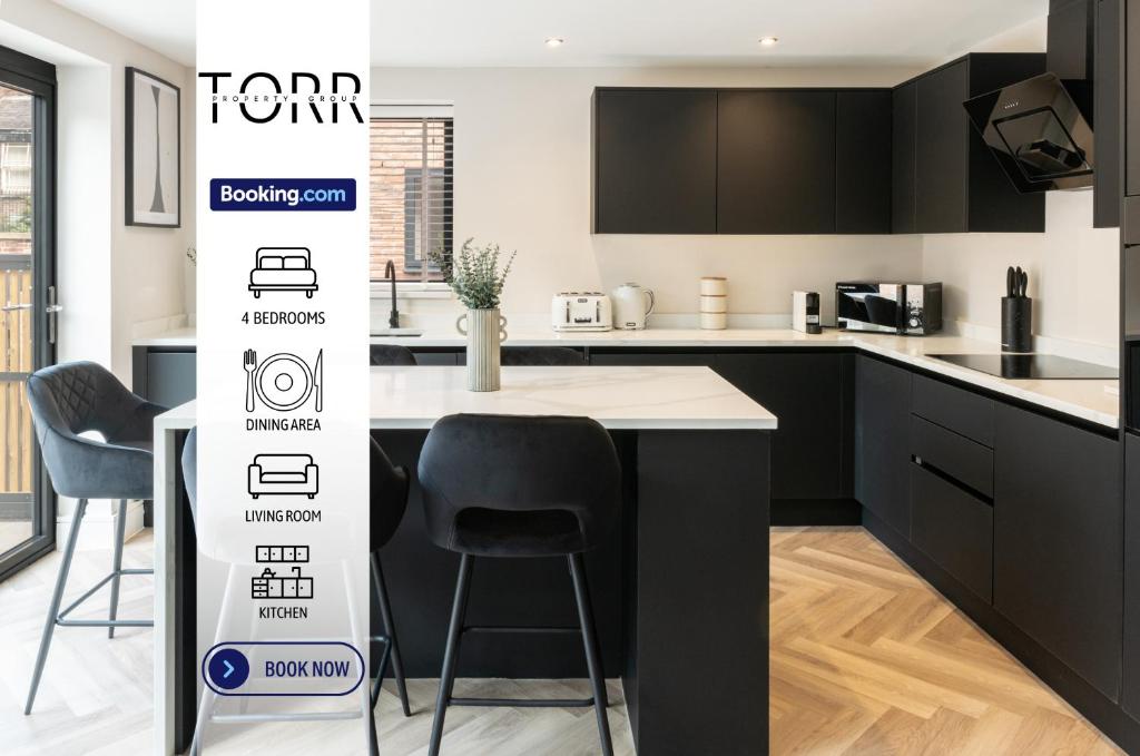 a kitchen with black cabinets and a table and chairs at Luxury 4BDR House By Torr Property Group Contractors Accommodation With Free Gated Secure Parking & Private Patio Garden Liverpool in Liverpool