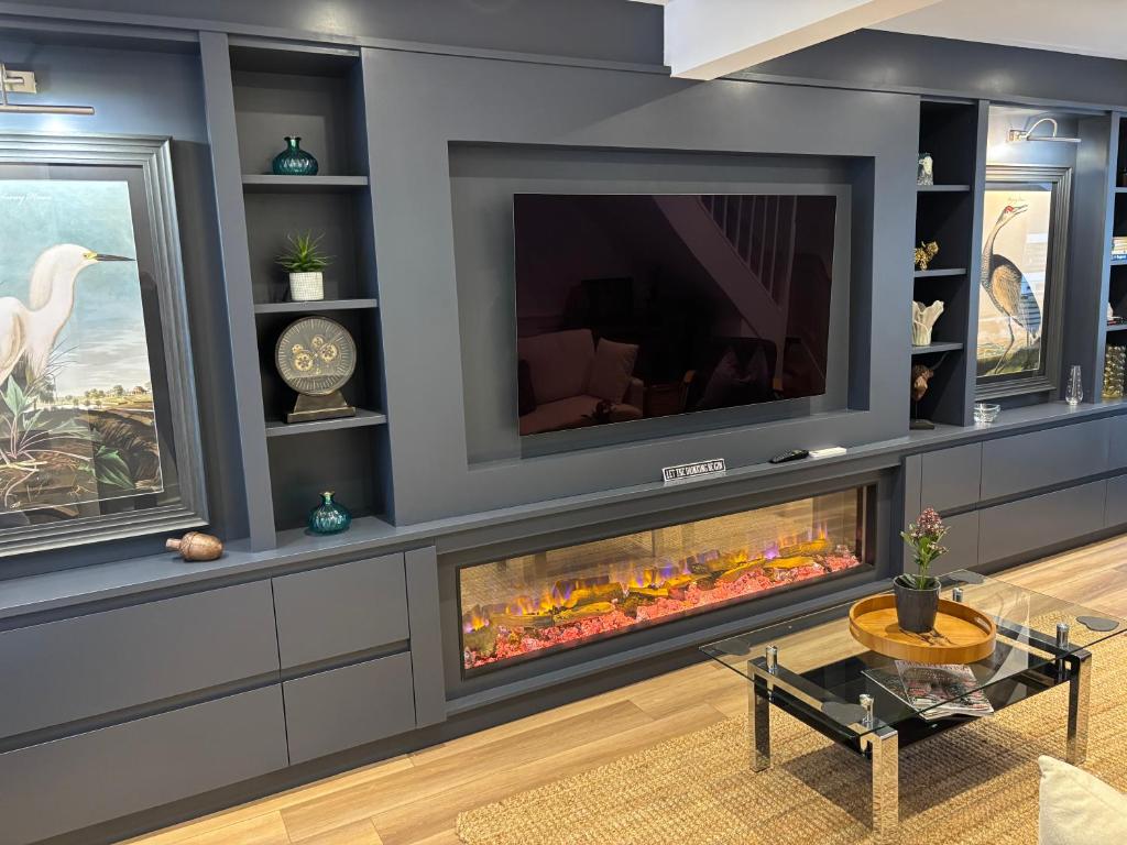 a living room with a fireplace and a tv at May Townhouse in Ulverston