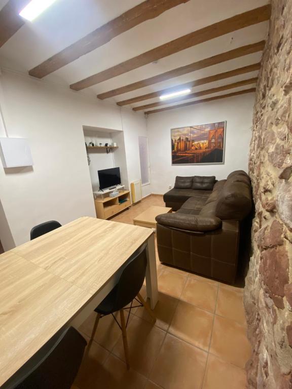 a living room with a table and a couch at Clau al castell apartament in Serra