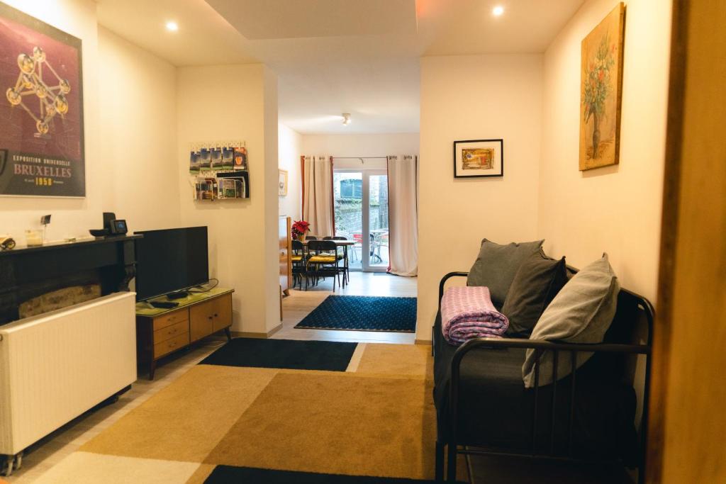 a living room with a couch and a television at Lyves in Liège