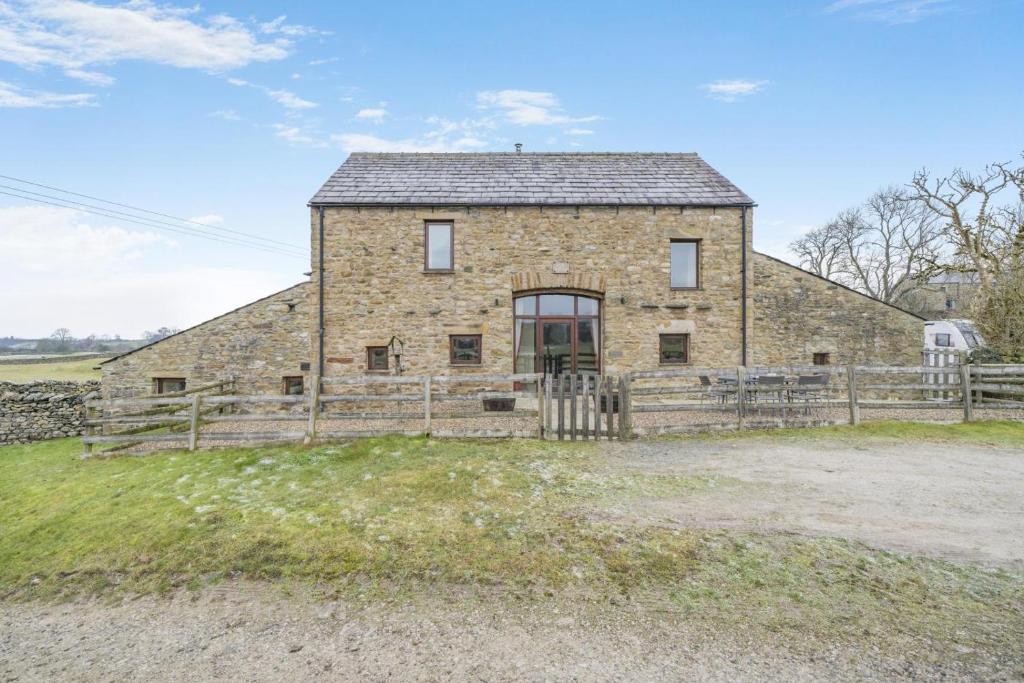 an old stone house with a wooden fence at 3 Bed in Ingleton oc-l34471 in Ingleton