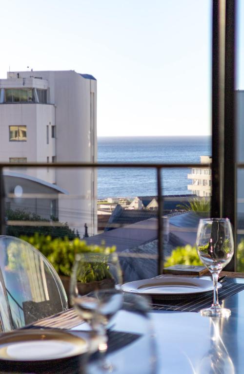 a table with a view of the ocean on a balcony at Namaste in Cape Town