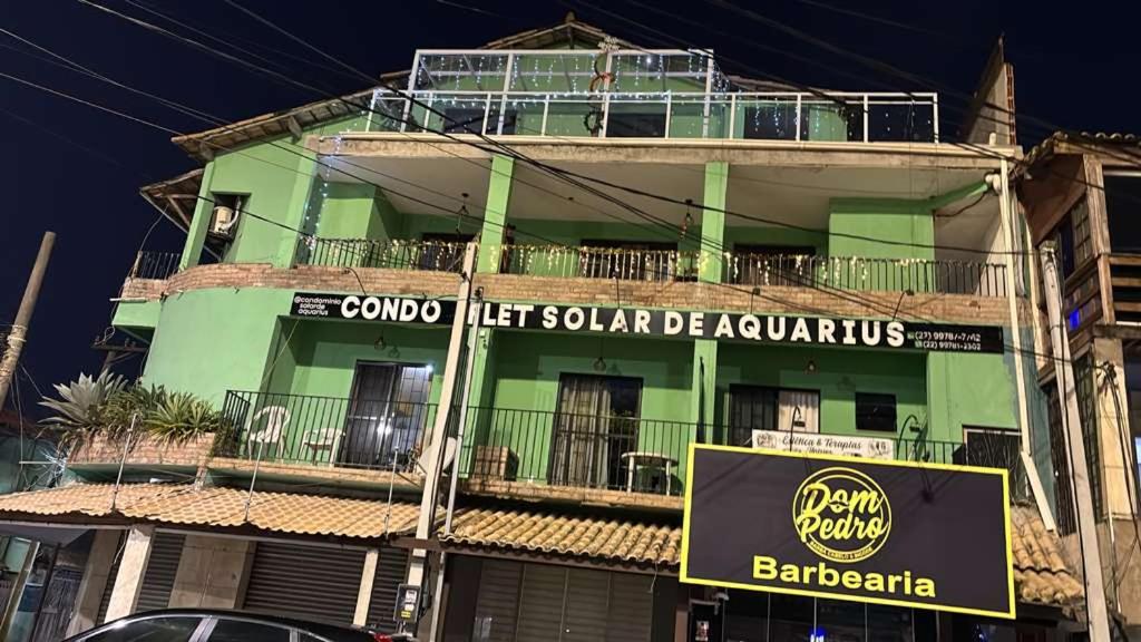 a green building with a sign in front of it at Condo Flat Solar de Aquários in Cabo Frio