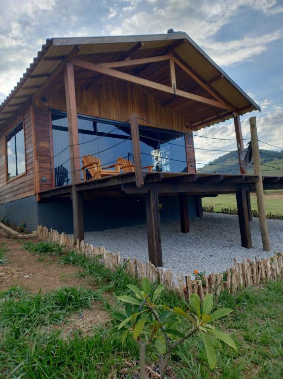 a wooden house with glass windows on a table at Chalé Céu Estrelado in Paraisópolis