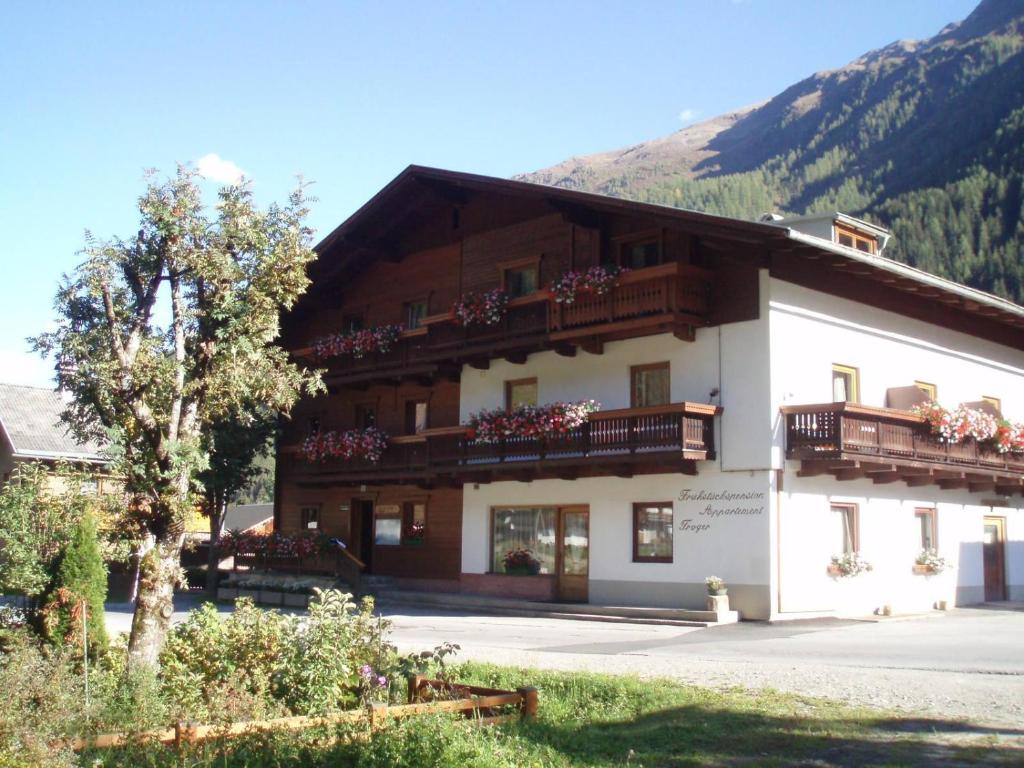 a large building with balconies on the side of it at Frühstückspension TROGER in Sankt Jakob in Defereggen