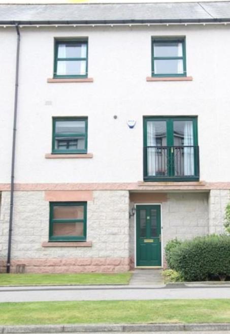 a white brick house with green doors and windows at Grandholm Crescent in Aberdeen