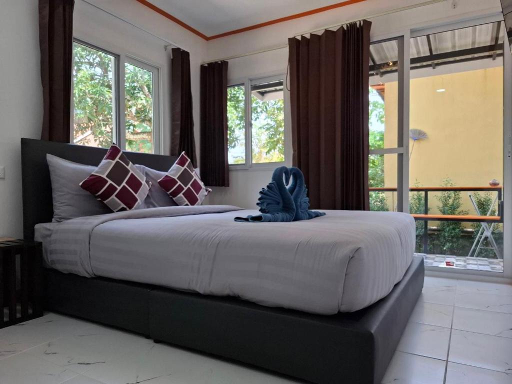 a bedroom with a large bed with large windows at NO name bangalow in Ko Lanta Yai
