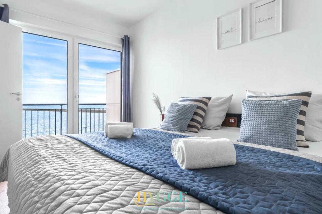 a bedroom with a large bed with a large window at Lodge 18 in Olpenitz