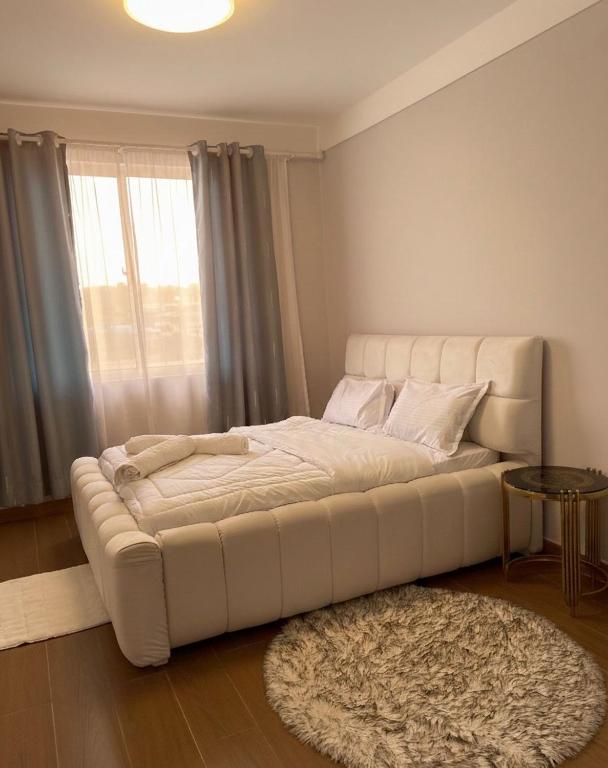 a large white bed in a room with a rug at deborahhomes in Marimbeti