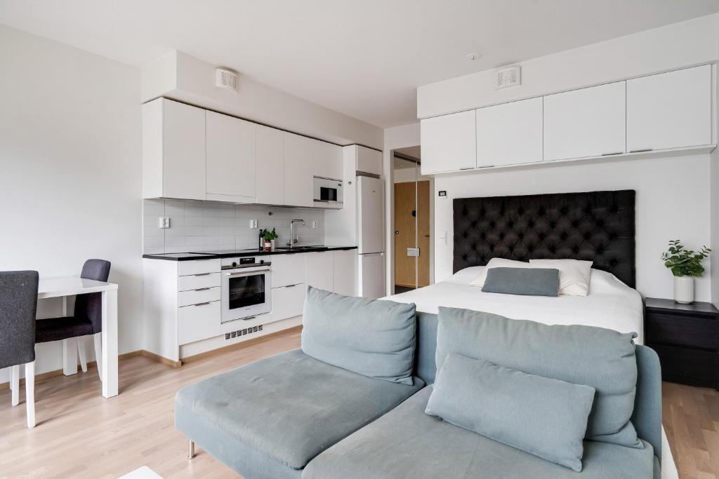 a bedroom with a bed and a couch and a desk at Simple studio for two in Turku Center in Turku