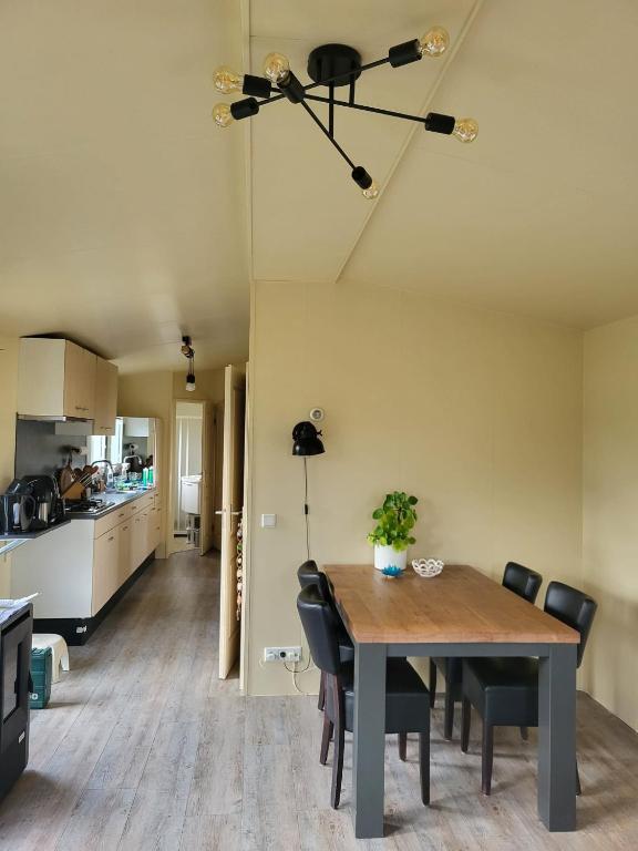 a dining room and kitchen with a table and chairs at Chalet in menaam in Dronrijp