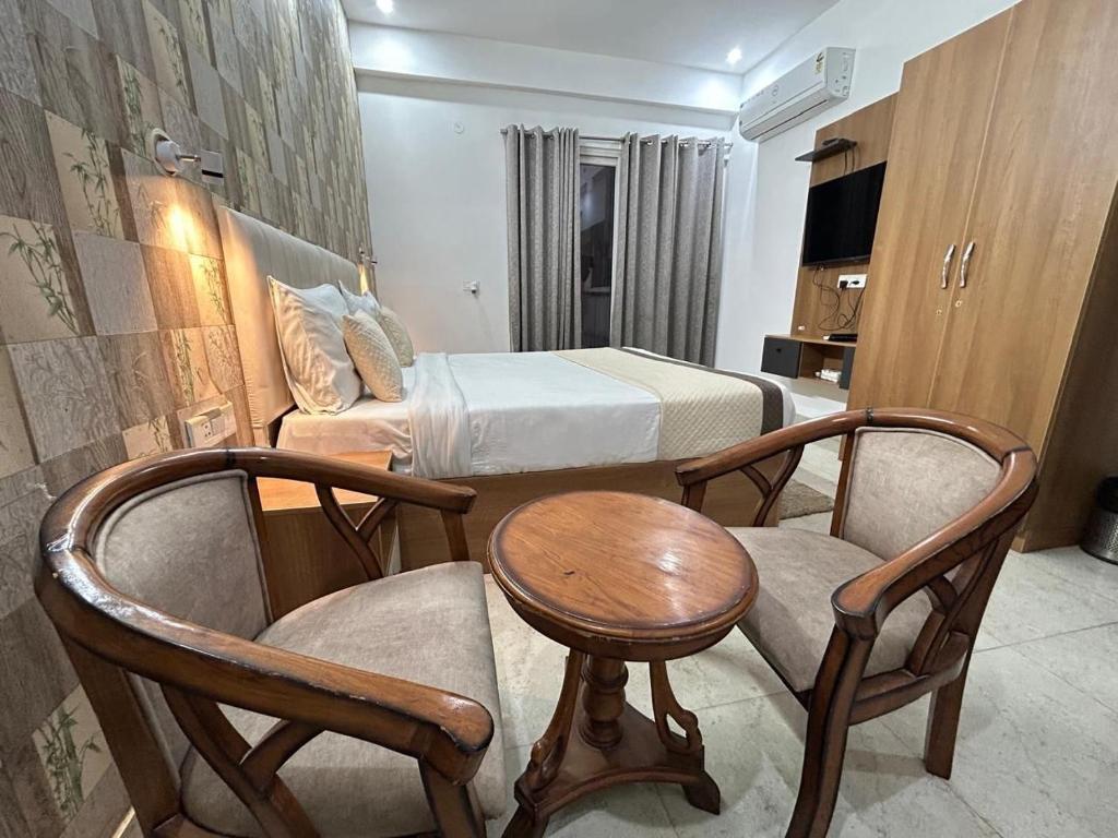 a hotel room with a bed and a table and chairs at The Grand Hotel Akshay in Gurgaon