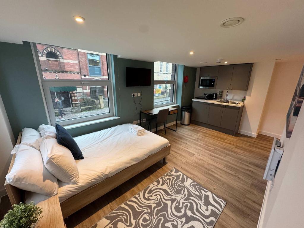 a bedroom with a large bed and a kitchen at Studio Flat Close to Queen Square - Flat 2B in Bristol