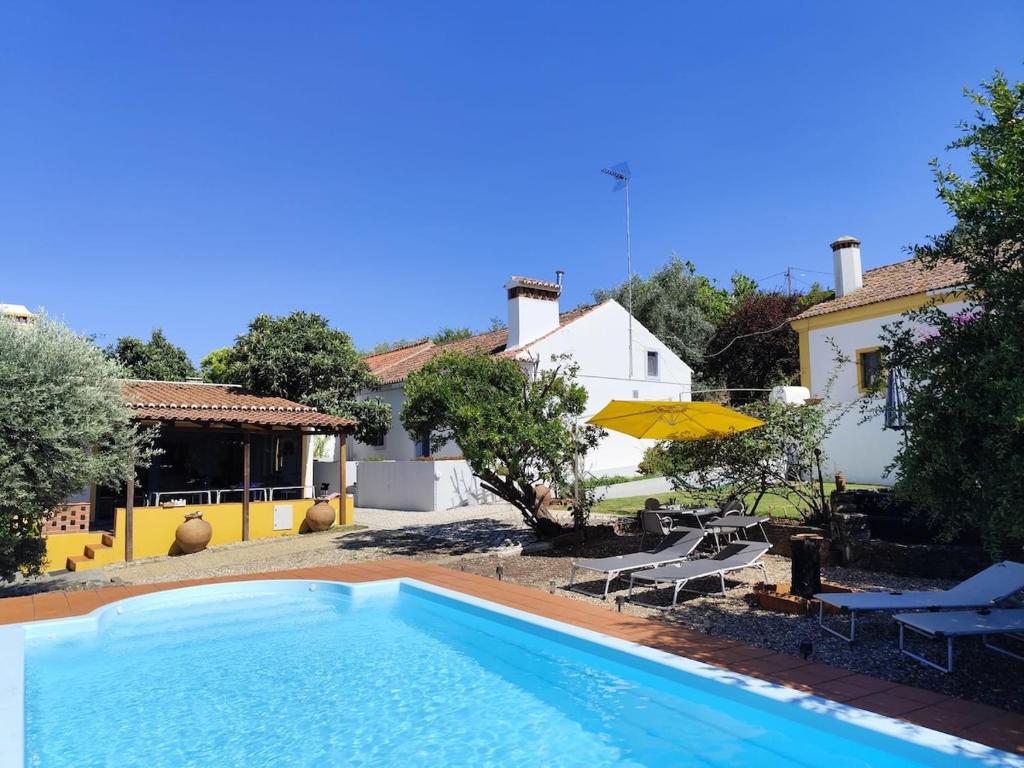 a large swimming pool in front of a house at Costas Guests in Sardoal