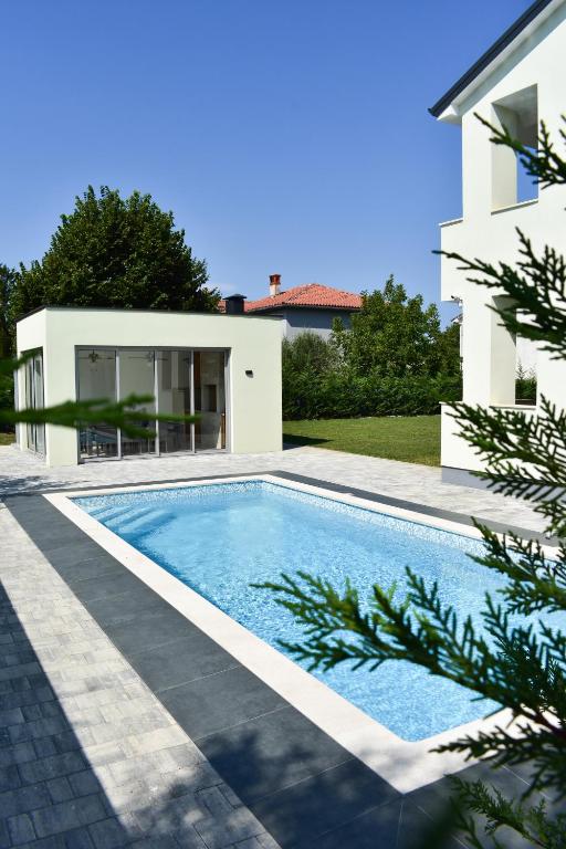a swimming pool in front of a house at Villa Majra in Valbandon