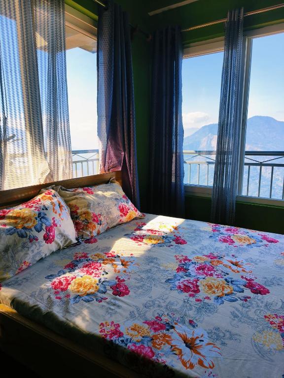 a bed with flowers on it in a room with windows at Petratos Homestay in Kalimpong