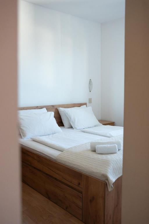 a bed with white sheets and pillows on it at Apartmani Roić in Gradac