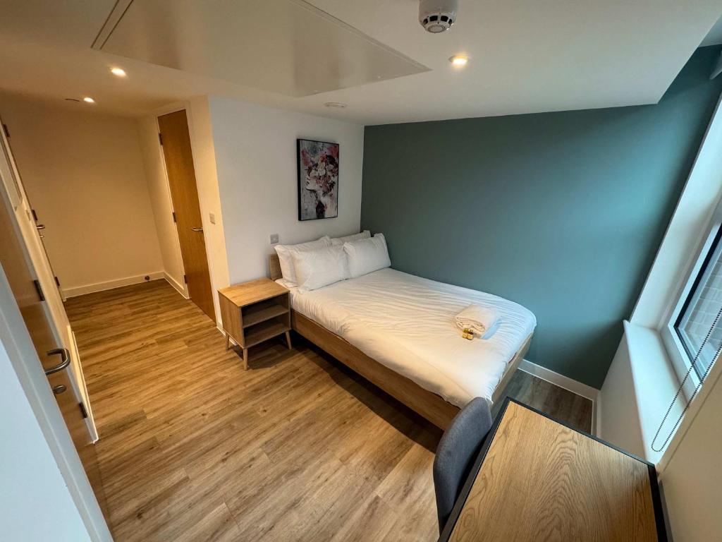 a small bedroom with a bed and a blue wall at Studio Flat Close to Queen Square - Flat 2A in Bristol