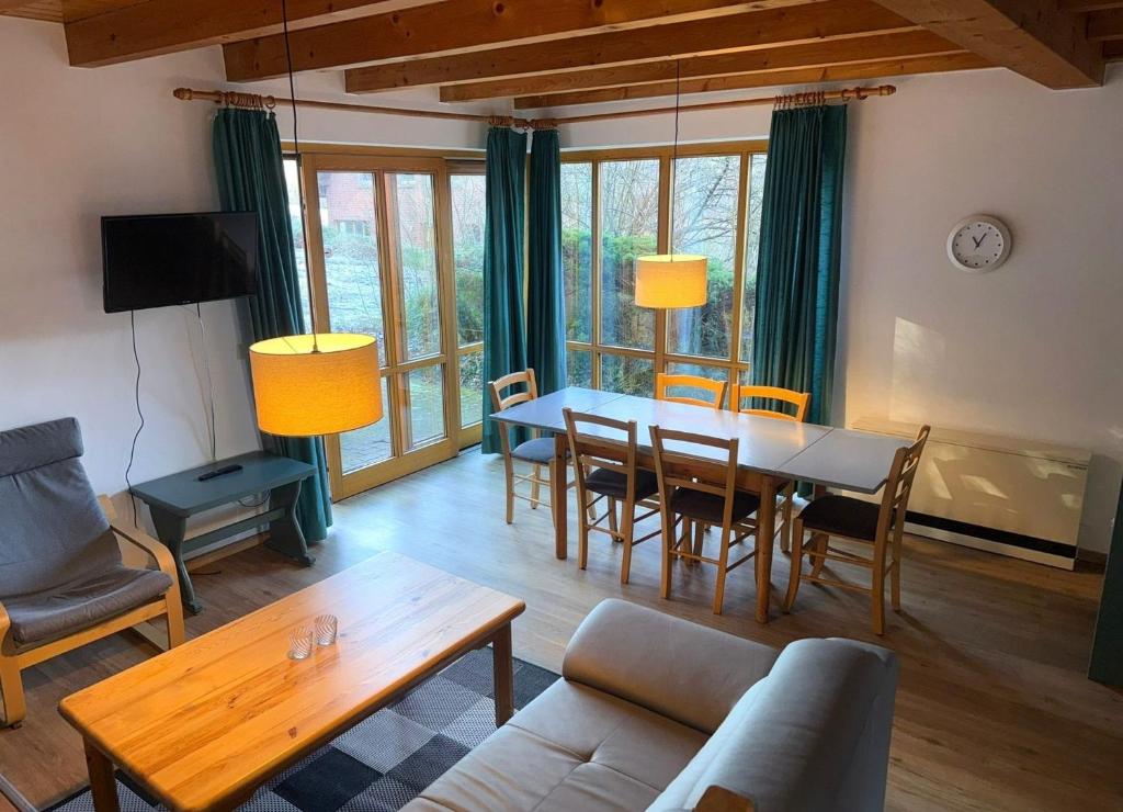 a living room with a dining room table and chairs at Haus 10 Die Kulisse Teutoburger Wald hautnah erleben in Natur Ferienpark in Nieheim