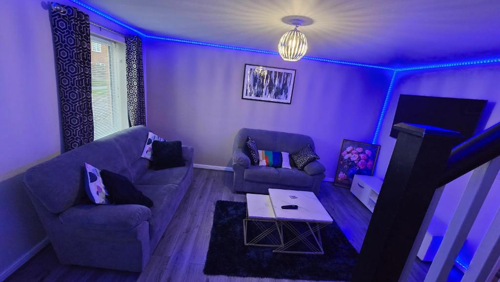 a purple living room with a couch and a table at Entire 3 bedroom luxurious house, Wigan , Manchester in Wigan