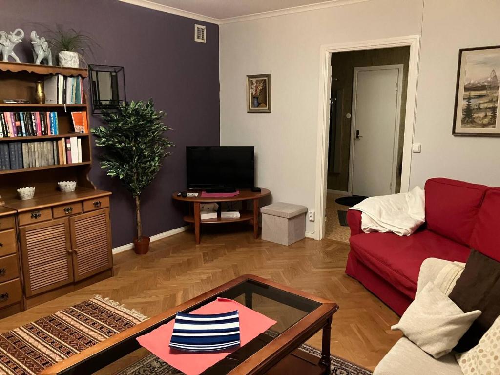 a living room with a red couch and a table at Large family housing in Mariannelund