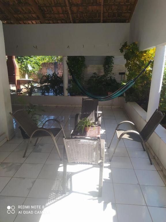 two chairs and a hammock on a patio at casa Beija Flor in Riachão